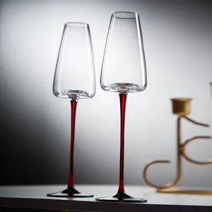 Elegante coppia di calici da champagne in cristallo con steli rossi e coppa a trapezio.