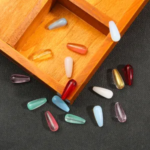 Perline di vetro colorate a goccia per gioielli fatti a mano su vassoio di legno