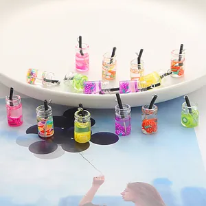 Detail view of colorful mini glass fruit bottle charms for DIY jewelry making.