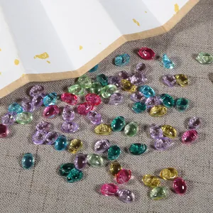 Gros plan de perles en verre colorées en forme de pétale de tulipe sur un tissu rustique DIY