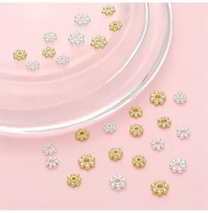 Detailed macro view of 14K gold-filled snowflake spacer beads for DIY jewelry making
