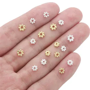 14K gold filled and silver flower snowflake spacer beads for DIY jewelry making on a hand.