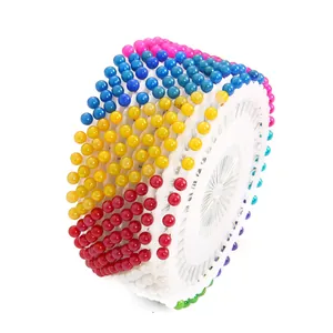Multi-colored pearl head sewing pins on a circular white wheel organizer