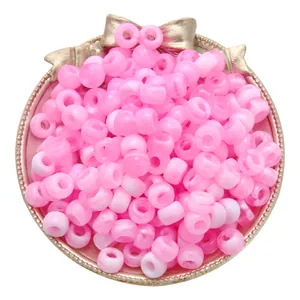 Pink and white two-tone acrylic large-hole barrel beads in a gold tray for DIY crafts