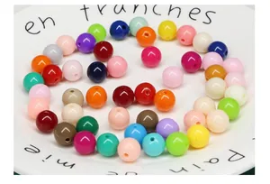 Vue macro détaillée de perles rondes en acrylique multicolores pour la création de bijoux