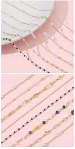 Detalle macro de cadenas chapadas en oro de 14k con perlas y cuentas de colores para joyería DIY