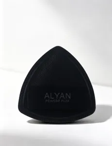Close-up of black triangular ALYAN powder puff with soft leather texture