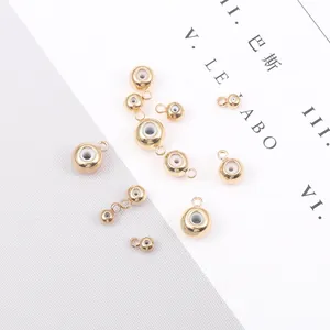 Macro detail of gold-plated copper slider beads with silicone inserts and hanging loops