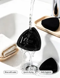 Detail view showing ALYAN black triangle Rubycell powder puff being washed under water.
