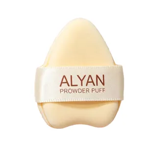 Soft cream colored curved triangle powder puff with ribbon strap for seamless foundation application