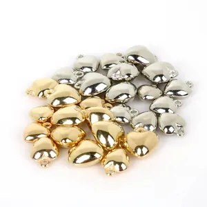 Macrodetail van metalen goud- en zilveren hartvormige CCB-kralen voor DIY-sieraden maken