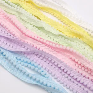 Nahaufnahme von Pastell-Polyester-Bommel-Spitzenbändern für DIY-Nähprojekte.