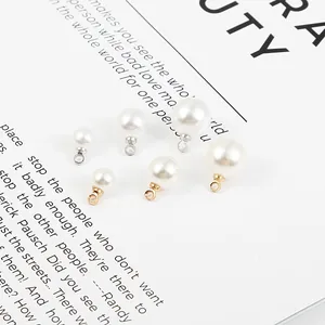 Gros plan de breloques en perles d'imitation avec boucles dorées et argentées pour bijoux