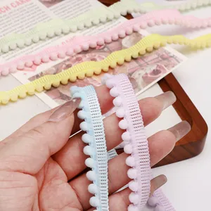 Detailaufnahme dekorativer Polyester-Pom-Pom-Spitzenborte in Pastellfarben für DIY-Bastelprojekte