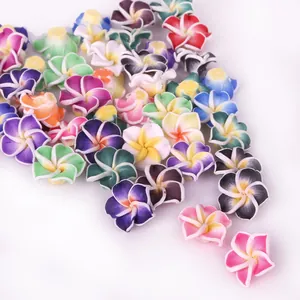 Macro view of colorful polymer clay frangipani flower beads for DIY jewelry making.