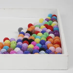 Close-up of colorful textured ABS berry beads for DIY jewelry making in a white tray