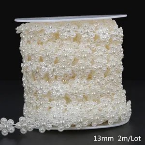 Detailed view of cream white 13mm flower-shaped ABS imitation pearl bead chain on reel