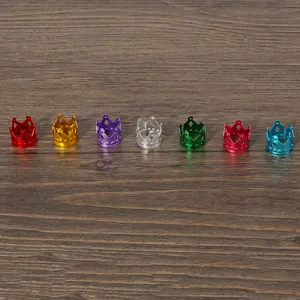 Close-up of vibrant crown-shaped aluminum jewelry beads in various colors on wood
