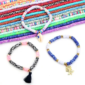 Gros plan de bracelets en perles heishi colorées avec breloques coquillage et rose