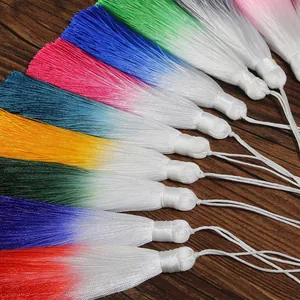 Close-up of vibrant 13cm gradient tassels in various colors on dark wood background