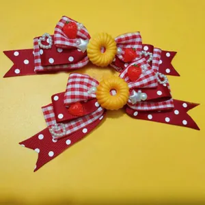 Dettaglio di fiocchi a quadretti rossi e bianchi con decorazioni di fragole e perle