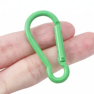 Detail of a green gourd-shaped aluminum carabiner clip held between fingers for scale.