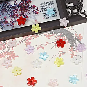 Detalle de cuentas de flores de cerezo de acrílico perlado para creación de joyas de bricolaje.