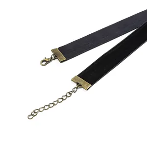 Detailed close-up of antique bronze ribbon crimp ends on black velvet fabric