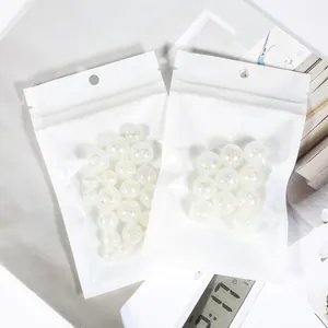 Detail showing iridescent acrylic bubble beads inside white protective zip packaging