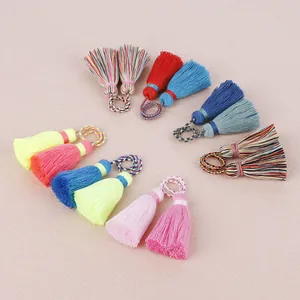 Vue détaillée de pompons en coton faits à la main pour la création de bijoux et pendentifs.