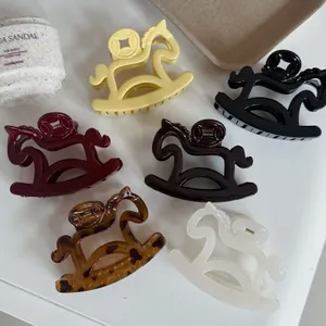 Detailed view of six colorful French rocking horse hair claw clips on a white surface.