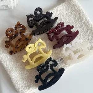 Detail view of 6 colorful rocking horse hair claws on soft textured fabric.
