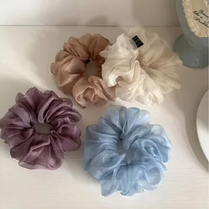 Detailansicht weicher Organza-Haargummis in gedeckten Violett-, Beige- und Blautönen