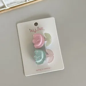 Detailed view of two cute tulip-shaped hair clips in pink and polka dot blue