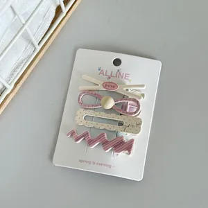 Detailed view of the 4-piece floral and pink hair clip set on a white display card