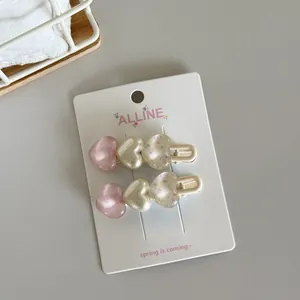 Detailed view of cute heart-shaped hair clips featuring floral and checkered patterns