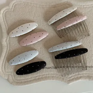 Detailed view of assorted polka dot hair combs in various soft pastel colors and black