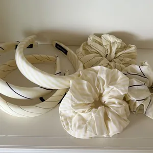 Detalle de cerca del conjunto de coletero y diadema ancha a rayas amarillo crema