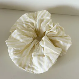 Primer plano de un coletero extragrande a rayas amarillo crema para un peinado muy dulce