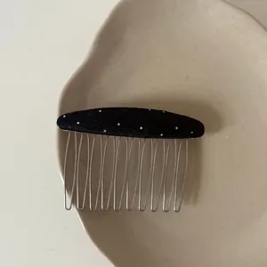 Detailed macro view of an elegant black polka dot hair comb featuring sturdy metal tines
