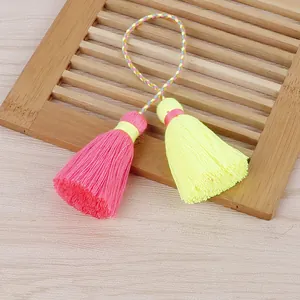Détail macro de glands doubles en fil de coton rose et jaune faits à la main déco