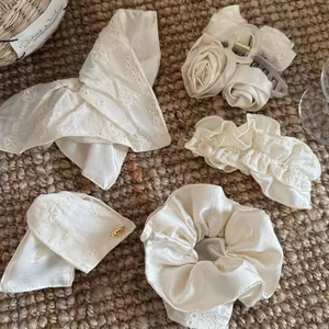 Detailweergave van crème kant en satijnen haaraccessoires op een mat