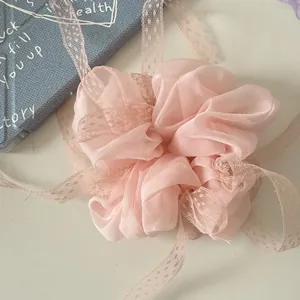 Primo piano di elastico per capelli in chiffon rosa con delicati nastri in pizzo
