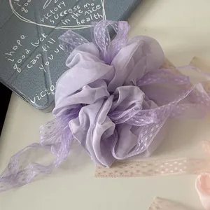Vista dettagliata di un elastico per capelli in chiffon lavanda con nastro di pizzo