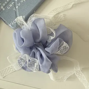 Dettaglio di elastico per capelli lavanda vintage con nastri in pizzo bianco.