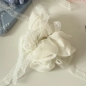 Primo piano di elastico in organza bianca con nastri in pizzo per acconciature