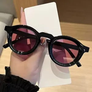 Detailed close-up of retro round sunglasses with black frames and purple lenses.