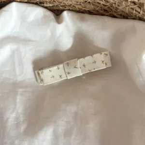 Détail en gros plan d'une pince à cheveux nœud floral avec imprimé fleuri