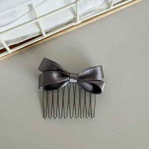 Close-up showing the shimmering gray satin bow detail of this Korean style hair comb