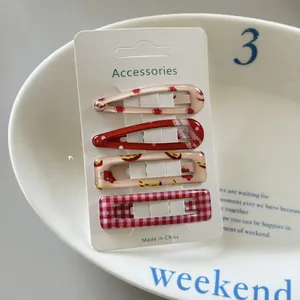 Detailed view of four colorful polka dot and plaid hair clips set on a display card.
